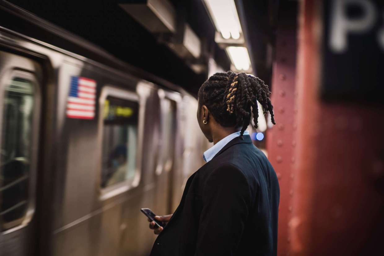 Man Waiting for Subway Transit on Phone